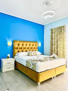 a bedroom with blue walls and a large bed at Villa Panorama in Sarandë