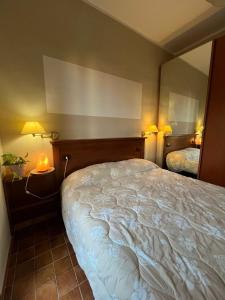 a bedroom with a large bed and a mirror at Il Glicine in Villasimius