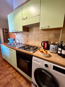 a kitchen with a stove and a washing machine at Il Glicine in Villasimius +32 photos