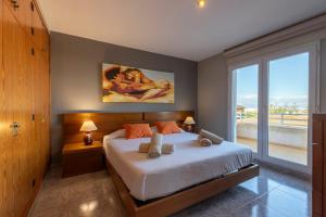 a bedroom with a large bed and a large window at Mallorca Casa Mar Blava in Llucmajor