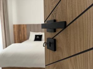 Una puerta de madera con una cama en un dormitorio en Apartament Lazur by Eleganckie Apartamenty Sianożęty - 100 metrów od plaży, wysoki standard, en Sianożęty 14 fotos más