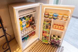 an open refrigerator filled with food and drinks at Casa Savana in São Paulo