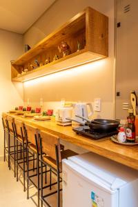 a kitchen with a bar with stools at a counter at Casa Savana in São Paulo