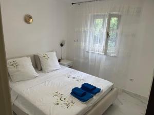 białe łóżko z dwoma niebieskimi ręcznikami w obiekcie Holiday Home 1 w Bibinje