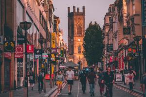 a group of people walking down a street with a clock tower at EPIC Duke Street Townhouse, City Centre Apartments in Liverpool