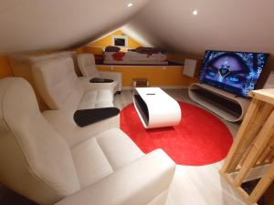 a living room with a white couch and a tv at Lake Loft in Alingsås