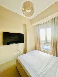una camera da letto con un letto bianco e una finestra di B3 Chic Sunset Studio Escape a Città di Iloilo