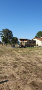a large field with a building in the background at La roulotte de Rochavelle in Chiché