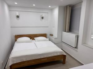 a bedroom with a bed with white sheets and pillows at Traumhaft moderne Ferienwohnung in 78554Aldingen in Aldingen