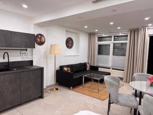 a living room with a black couch and a table at Traumhaft moderne Ferienwohnung in 78554Aldingen in Aldingen +8 photos