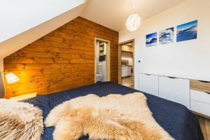 a bedroom with a bed with a wooden wall at 3 Apartmány SKI Jasná in Demanovska Dolina