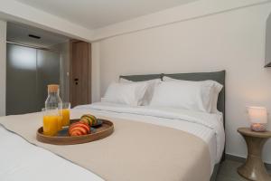 a tray of fruit and juice on a bed at The Minion Elegant Suite - Acropolis View in Athens