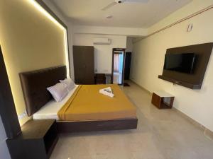 a bedroom with a bed and a flat screen tv at Jerry's Chateau in Pondicherry