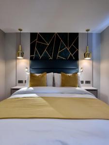 een slaapkamer met een groot bed met gele kussens bij Hotel London in Londen