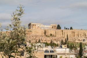 a building on top of a hill with houses at The Minion Elegant Suite - Acropolis View in Athens