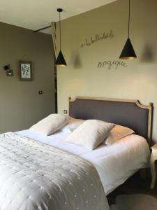 une chambre avec un grand lit avec deux oreillers dans l'établissement La Longère de Chillac campagne chic jacuzzi, à Morizès