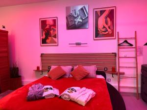 a bedroom with a red bed with two slippers on it at Liberty walk in Montmorot