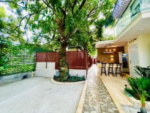 a tree in front of a house with a fence at Glamping Arena in El Porvenir