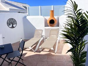 a patio with chairs and a table and a plant at Studio El Tucan in Nazaret