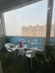 a balcony with a table and chairs and a large window at Luxury Stay by Good vibes studio in Ghaziabad +17 photos