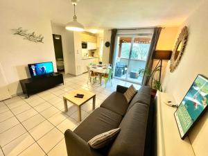 een woonkamer met een bank en een tafel bij " Côté Parc " Cité de l'espace - Entrée autonome in Toulouse