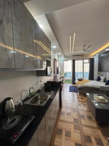 a kitchen with a sink and a living room at Luxury Stay by Good vibes studio in Ghaziabad