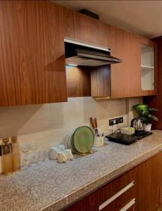 a kitchen with wooden cabinets and a green plate on a counter at Liv box hotel in Rājpur