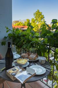 a table with plates of food and a bottle of wine at Penelope's Stellenbosch in Stellenbosch