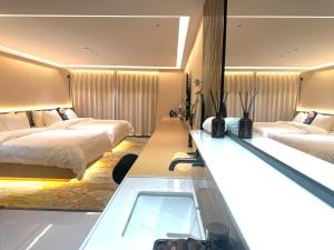 a hotel room with two beds and a mirror at Purple Stone High-End Designer Loft in Harbin