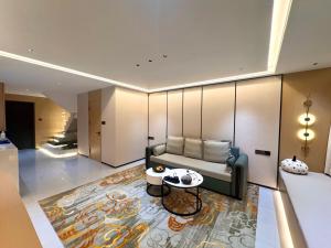a living room with a couch and a table at Purple Stone High-End Designer Loft in Harbin