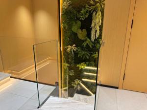a glass door in a room with a plant at Purple Stone High-End Designer Loft in Harbin