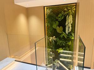 a staircase in a house with a wall of plants at Purple Stone High-End Designer Loft in Harbin