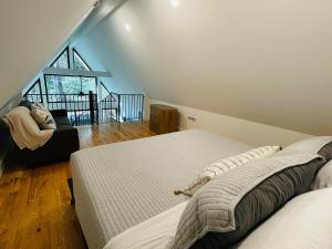 a bedroom with a large bed and a staircase at The Bungalow at Valley Bear Farms Resort in Balsam Grove