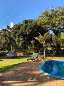a hot tub and a bench next to a park at Pousada Canto dos Passaros in Chapada dos Guimarães