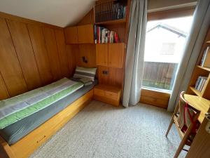 a small bedroom with a bed and a window at Haus Kilian in Schruns-Tschagguns