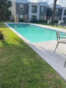 a swimming pool with a bench in a yard at Wildrose Villas in Brownsville