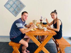 een man en een vrouw aan een houten tafel bij Villa Prime Time Unawatuna in Unawatuna