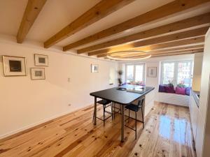 a kitchen with a black table in a room with wooden floors at Atelier du Joaillier in Mulhouse