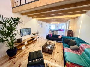 a living room with a green couch and wooden floors at Atelier du Joaillier in Mulhouse