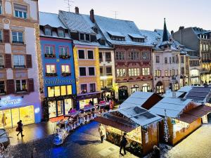 a group of people walking around a city with buildings at Atelier du Joaillier in Mulhouse