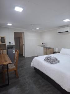 a bedroom with a bed and a table and a kitchen at Kudu Kottage in Phalaborwa
