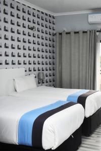 two beds in a hotel room with two at Avrila Springs Hotel in Gaborone