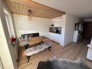 a living room with a wooden table and a kitchen at Kuschelnest im Chalet Chic, Inkl "Oberstaufen Plus Card" in Oberstaufen