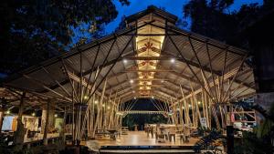 a large wooden building with a roof at night at Danta Corcovado Lodge in Rincón
