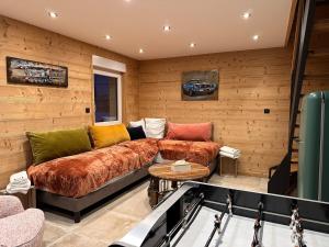 un salon avec un canapé et une table dans l'établissement Chalet PLUME D'EAU - jacuzzi, piscine et pétanque, à Gerbépal
