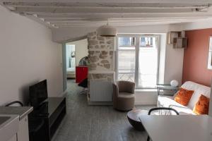 a living room with a couch and a tv at Cozy apartment in Le Marais in Paris