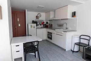 a kitchen with white cabinets and a counter and chairs at Cozy apartment in Le Marais in Paris +7 photos