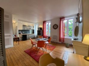 a living room with a table and chairs at Au logis de Abi in Cherbourg en Cotentin