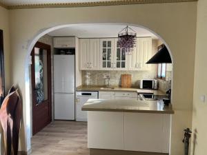 a kitchen with white cabinets and a white refrigerator at Precioso chalet en la playa de Tavernes de la Valldigna in Tavernes de Valldigna