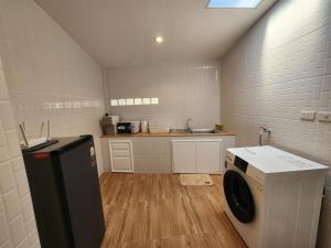a small kitchen with a washing machine and a counter at 19 House in Ban Khlong Pleo